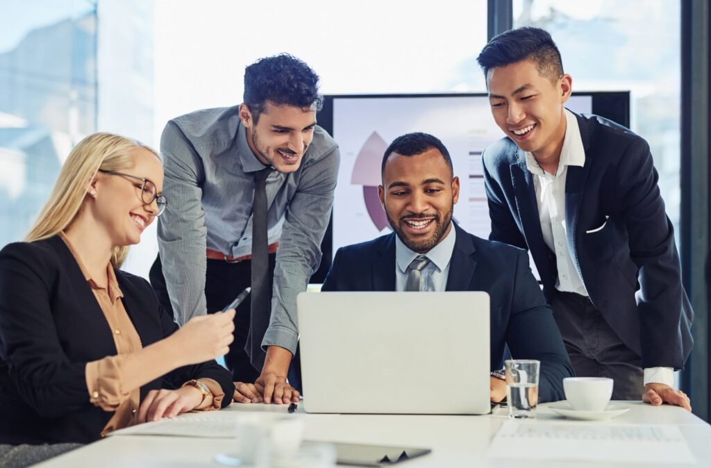 Team gathered around a laptop to use mortgage technology